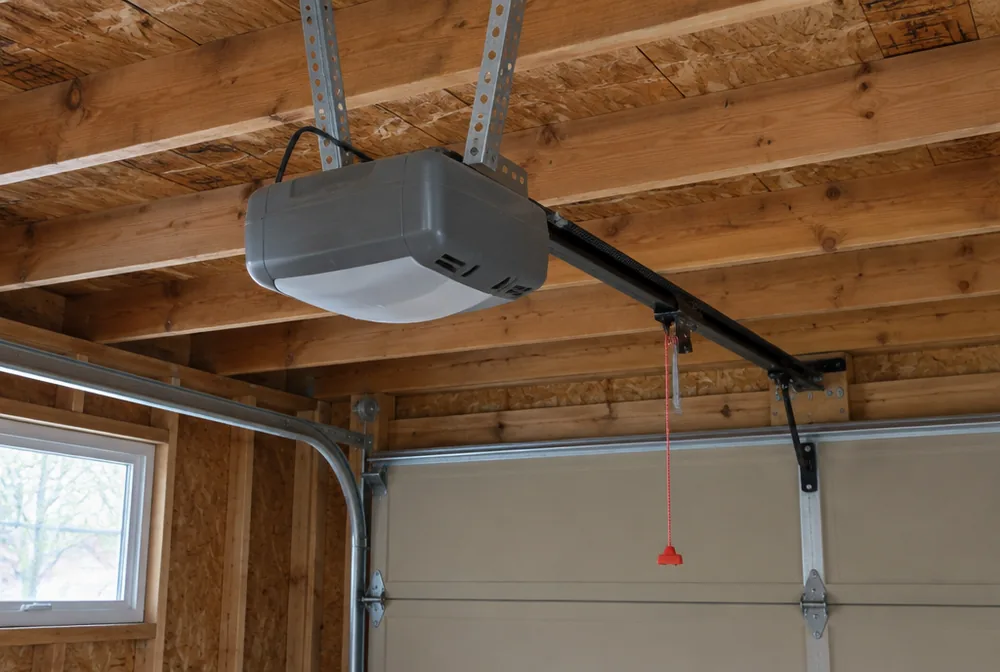 Garage door opener motor unit mounted on the ceiling of a residential garage